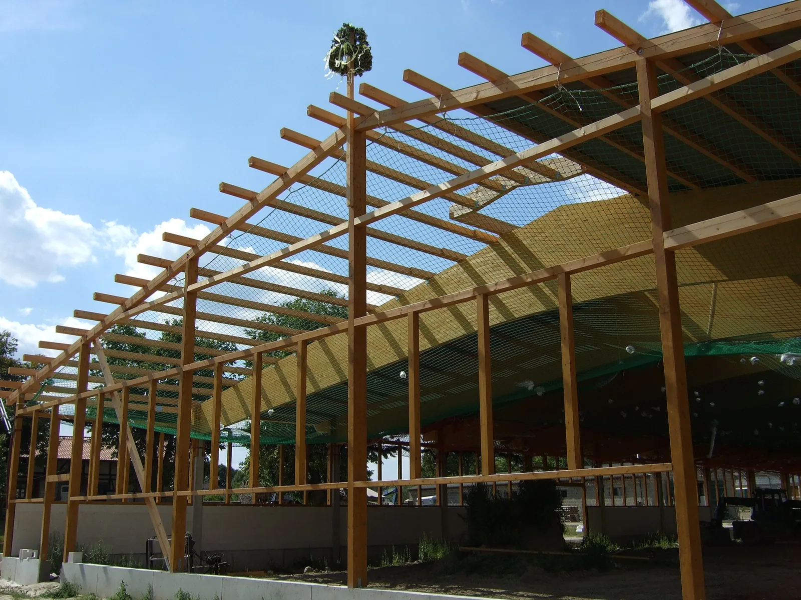 Exposed timber beams and roof rafters above a building site.