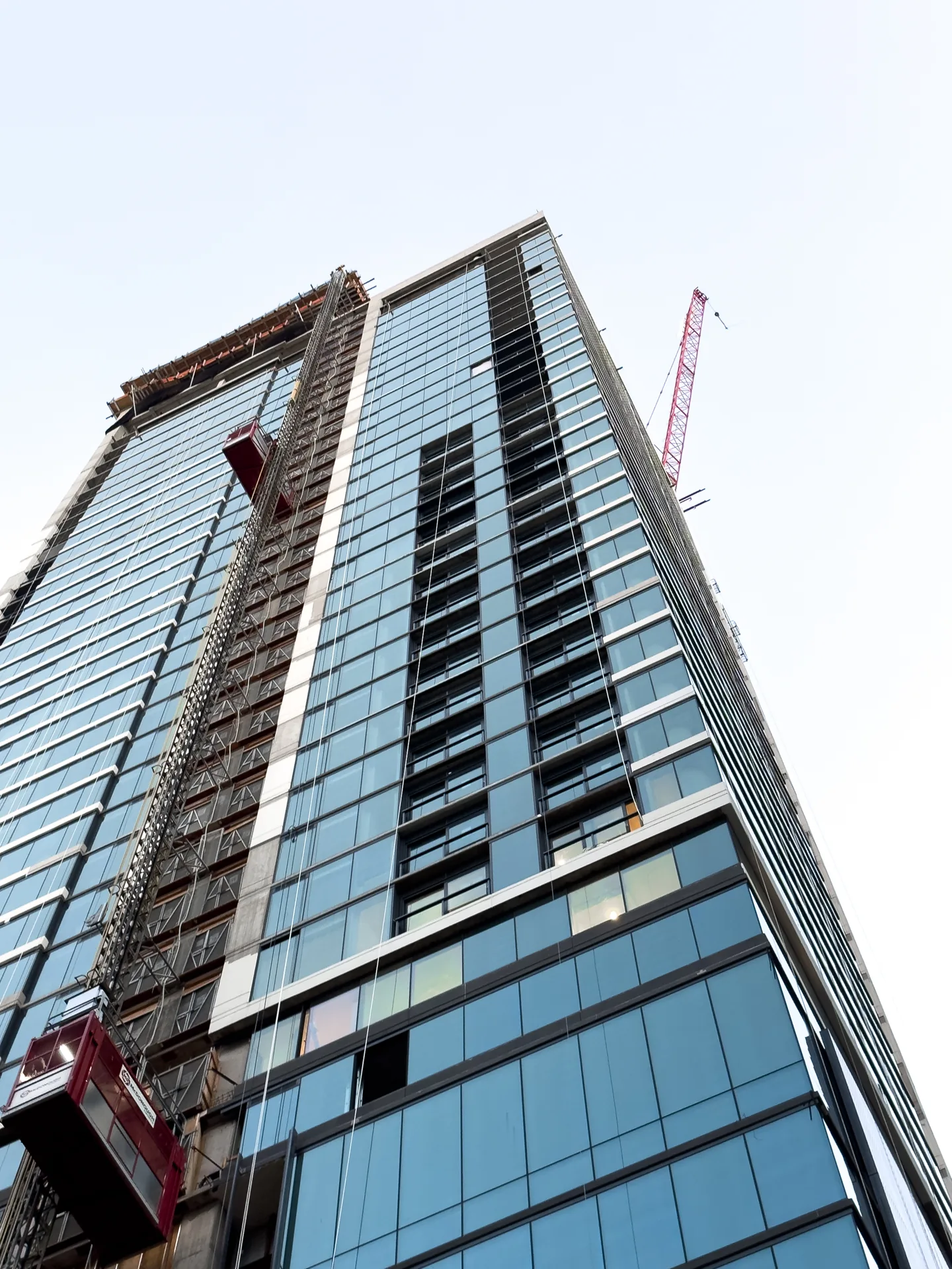 Glass tower with a construction hoist along the facade.